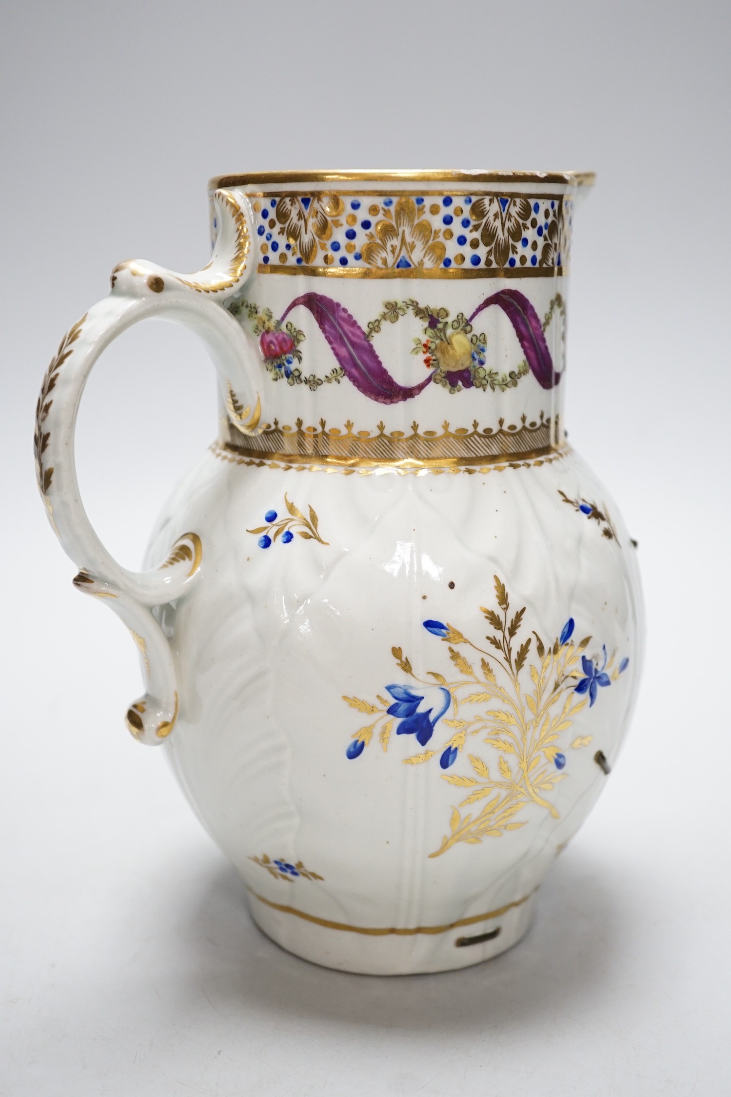 An 18th century Caughley very rare polychrome mask jug, elaboratley painted and gilded with two initials in a dry blue and gilt wreath, Gittins Col., Pictured Caughley Bicentenary Exhibition 1999, with labels, 19cms high